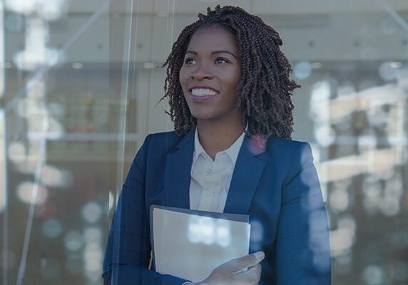 smiling woman looking hopeful holding file
