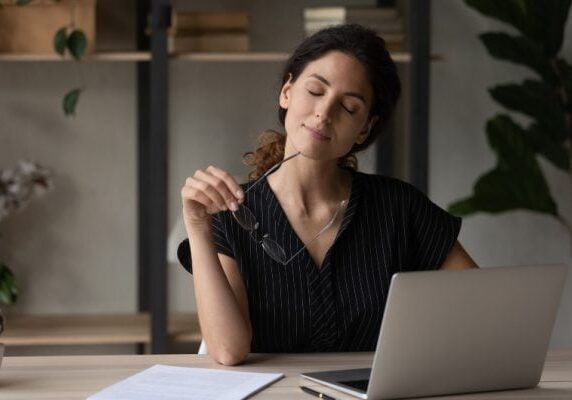 coach taking a moment to close her eyes at her laptop