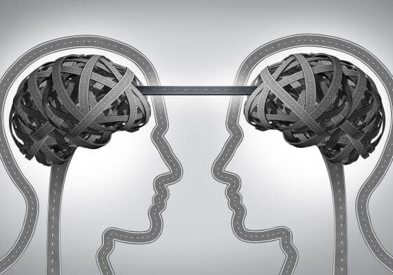 two heads facing eachother with brains connected by a road way depicting emotional intelligence