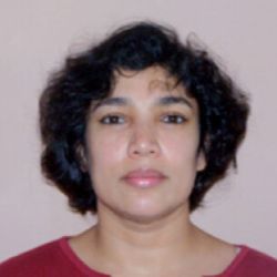 Dr Sharmila Pixy Ferris headshot photo, woman with dark hair wearing red top in front of white wall