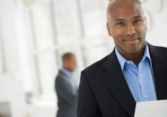 coach smiling with someone behind him blurred