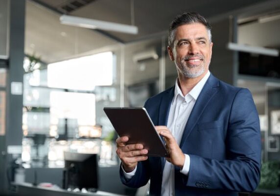 man holding a tablet standing in an office
