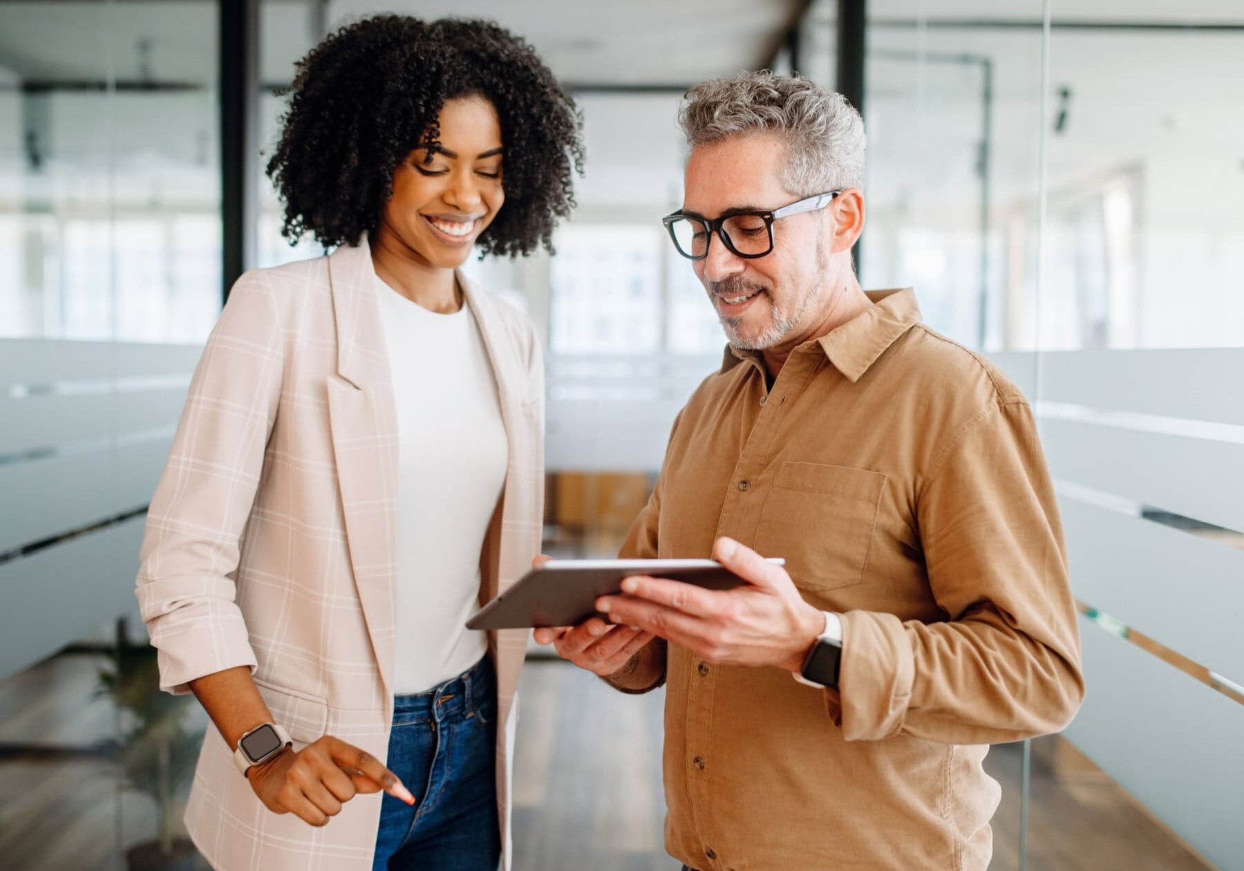 A man and woman deep dive into the content on a tablet