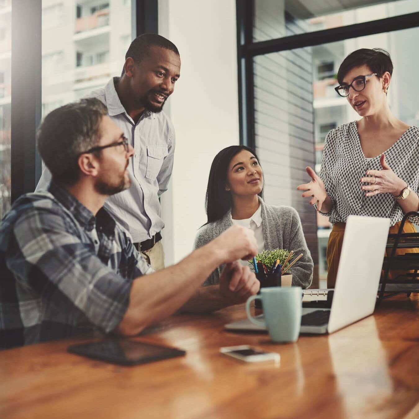 A group of professional coaches in an organization gather in an office setting
