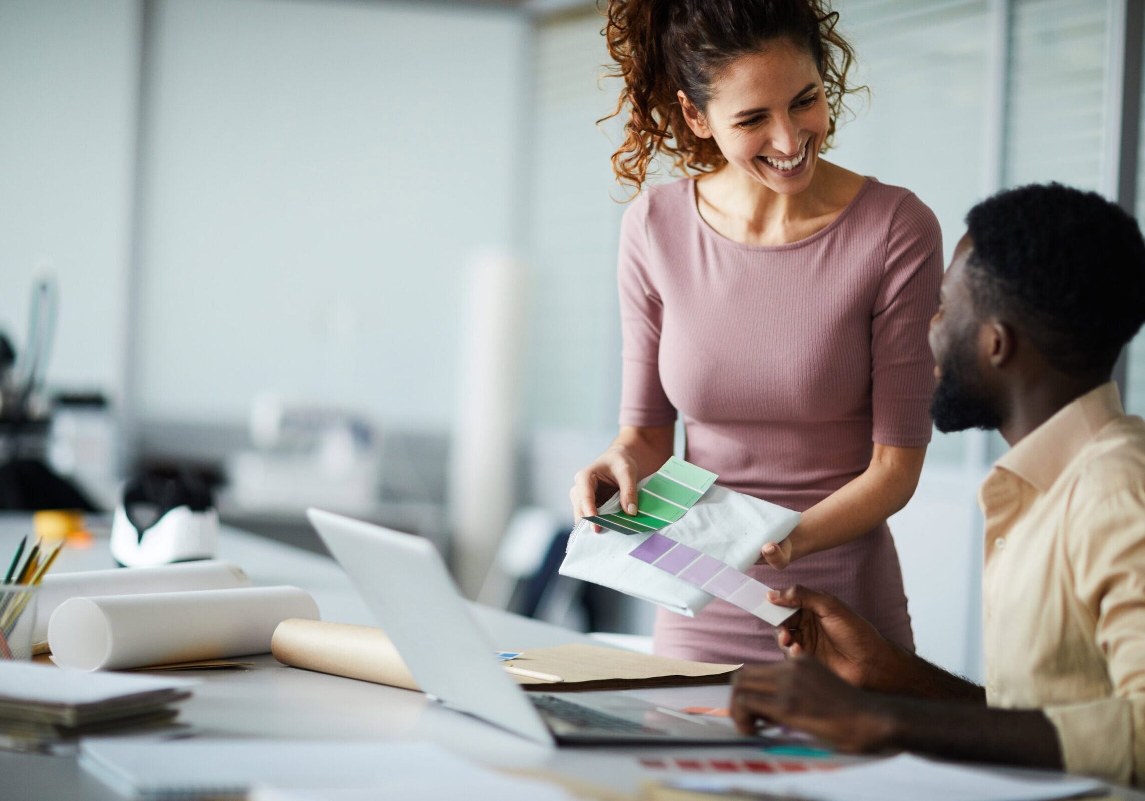 Two professionals reviewing color samples together at a desk in an office