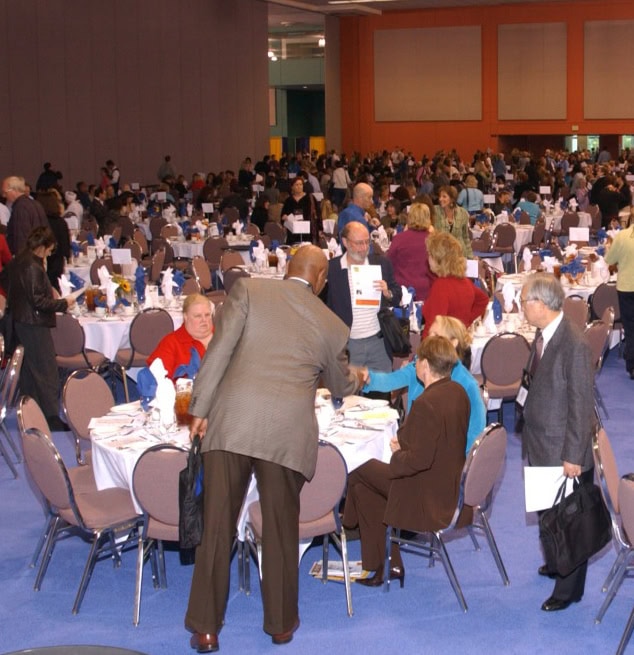 A diverse group of individuals engaged in conversation and connecting with one another at the 2005 International Coaching Federation Annual Conference.