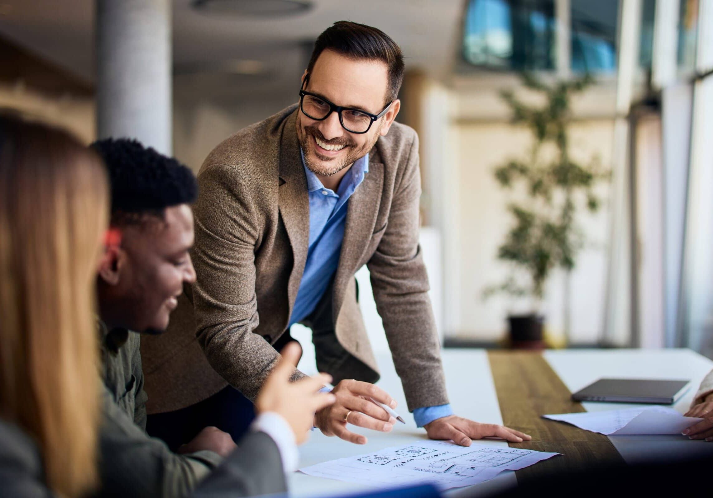 Professionals gathered around a table discussing plans in an office