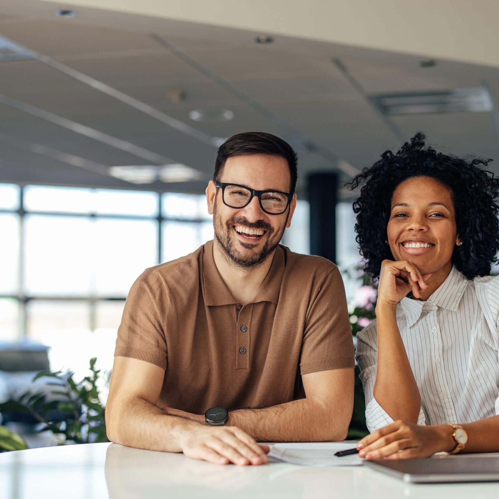 A man and a woman sitting smiling in a business office