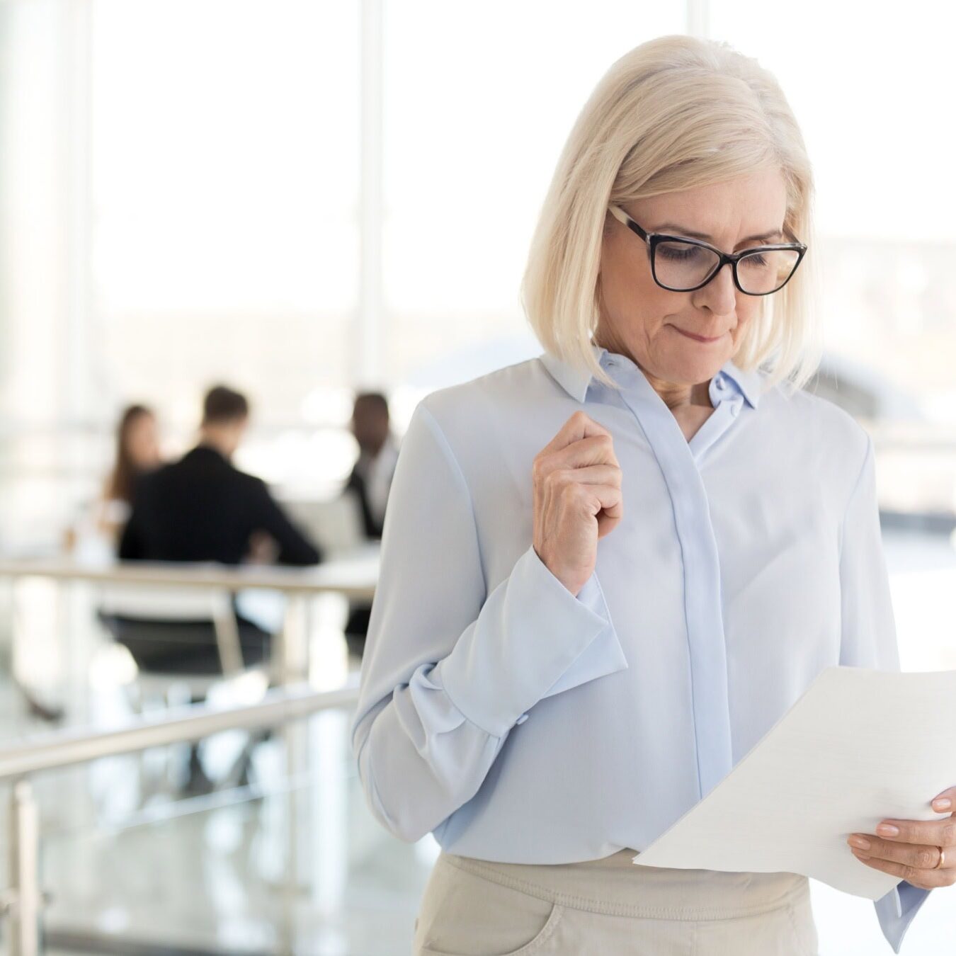 A woman reading a document of the ICF Core Competencies in an office space