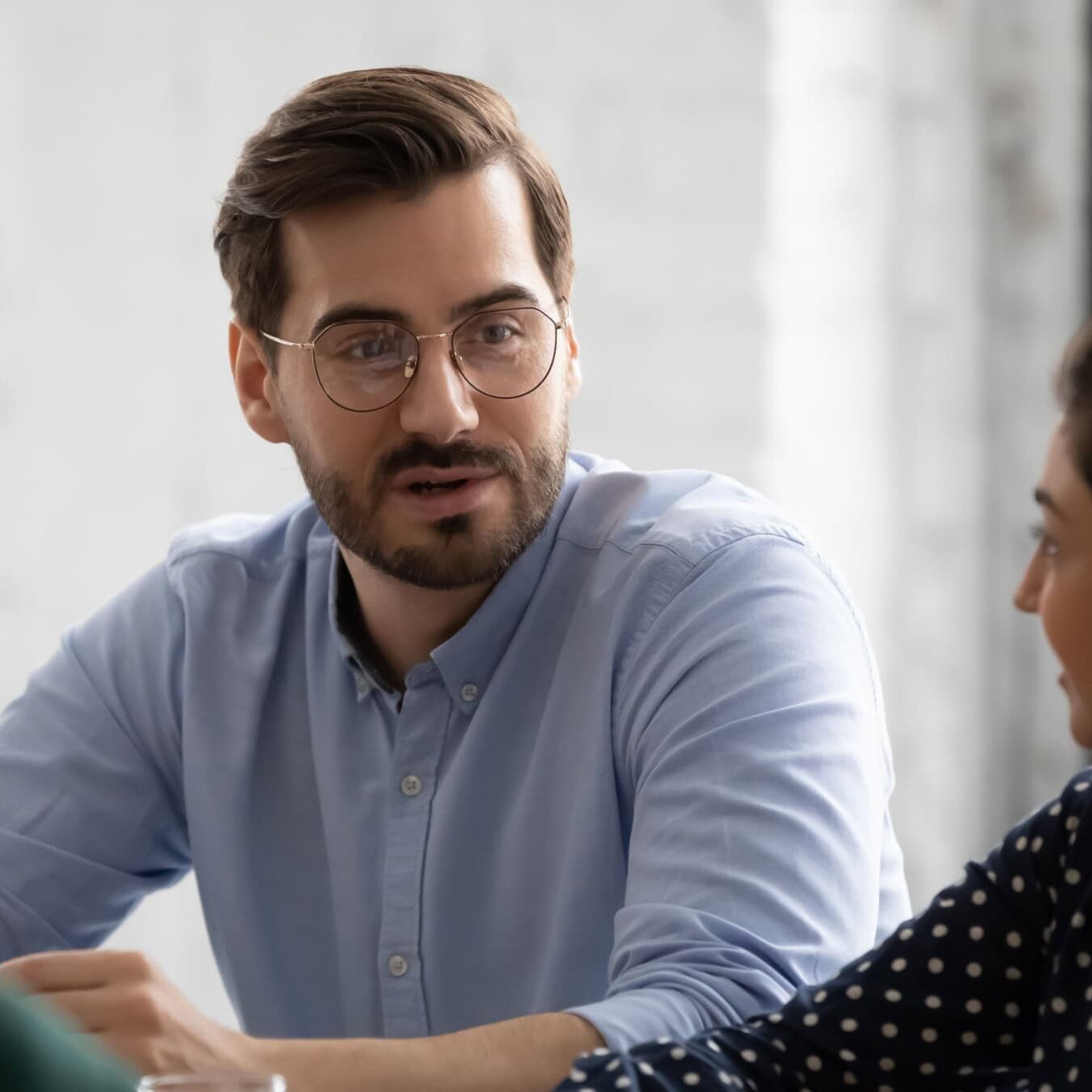 A man is talking with another woman in an office setting diving into coaching consumer complaints