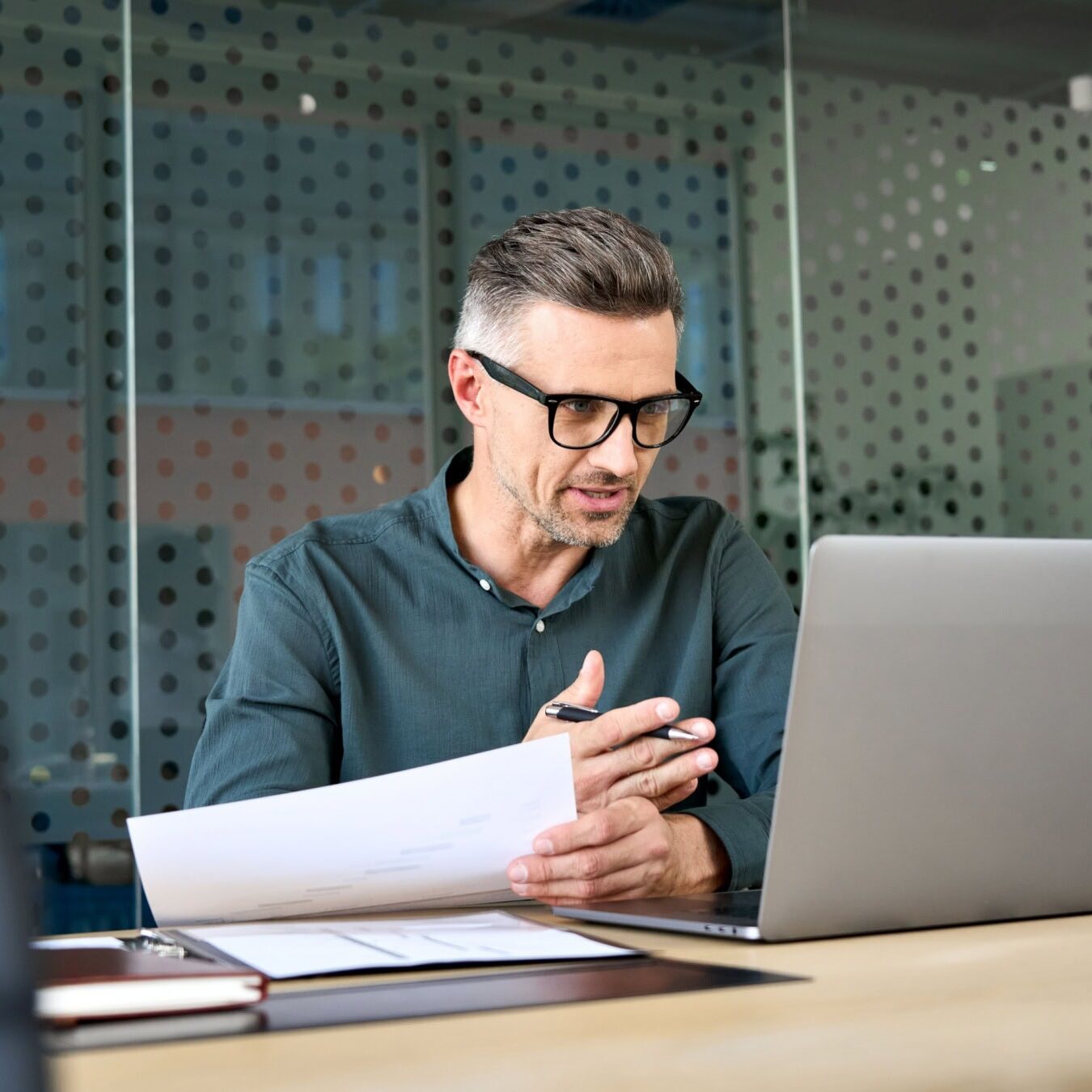 A man uses a laptop in an office setting to look at the ICF exams.