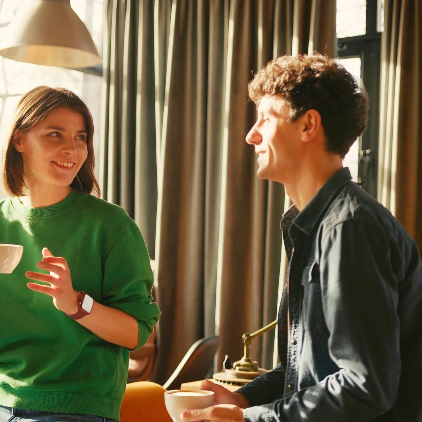 Man and woman having a relaxed conversation while holding coffee cups