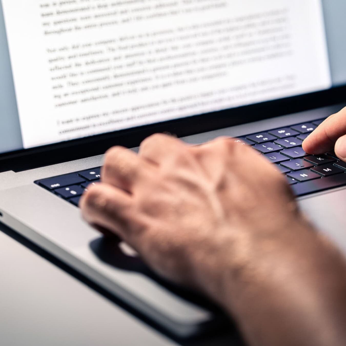 A person types up the key findings of a research report onto a laptop
