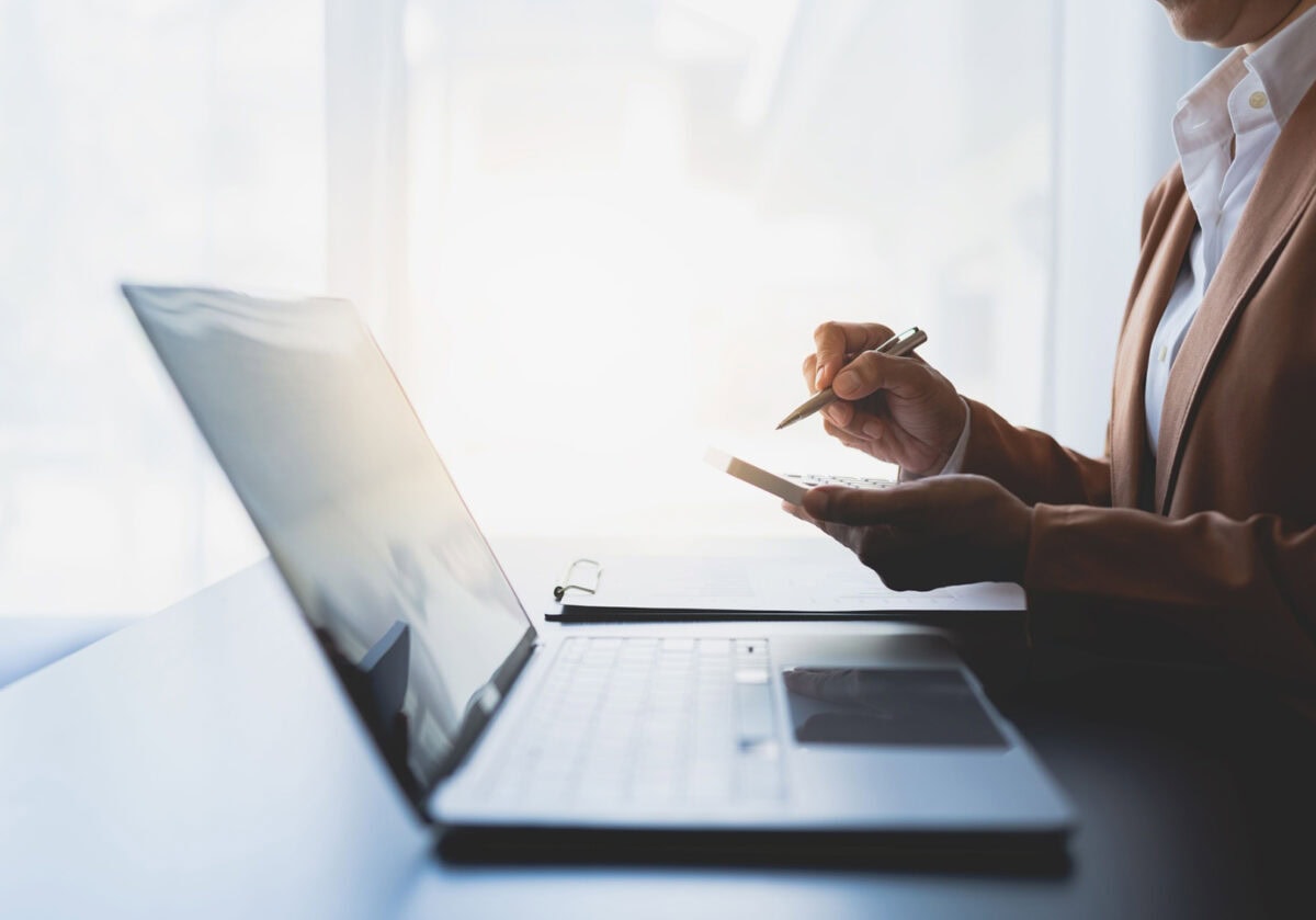 Woman working on a laptop, representing building a coaching website to attract clients.