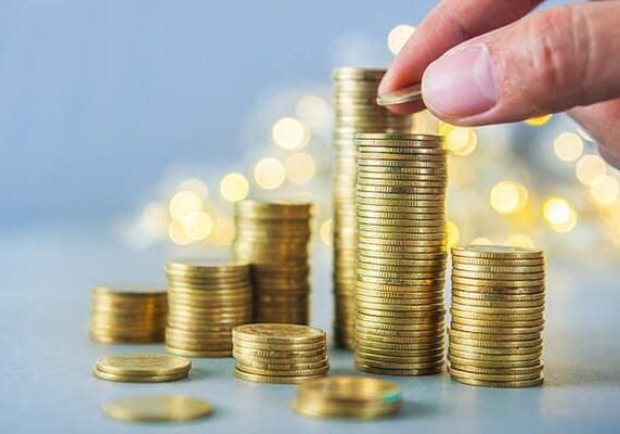 stacking gold coins on a table
