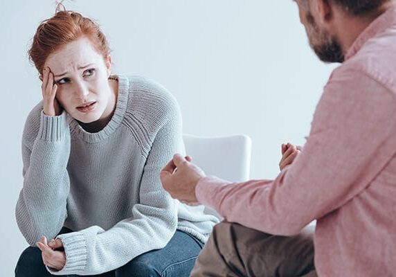 distraught woman listening to man in a counseling or coaching session