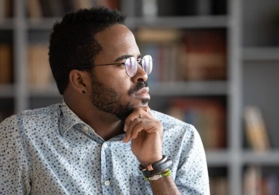man thinking while looking out of a window