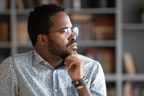man thinking while looking out of a window