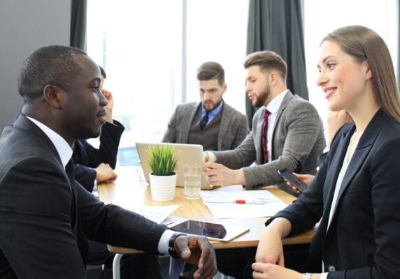 two people meeting with three others meeting behind at the same table