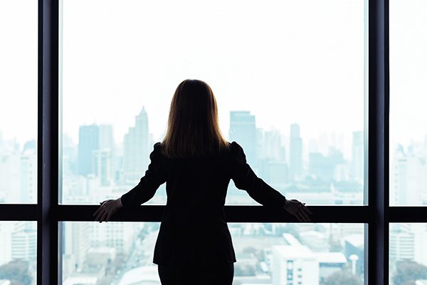 coach standing at a window looking over a city