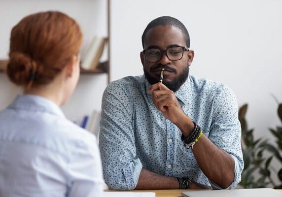 coach client dissonance, two people at a table not agreeing during a conversation