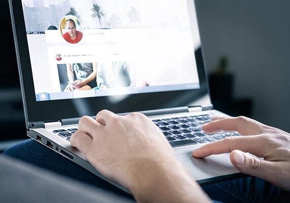 coach updating their social media profile on a laptop