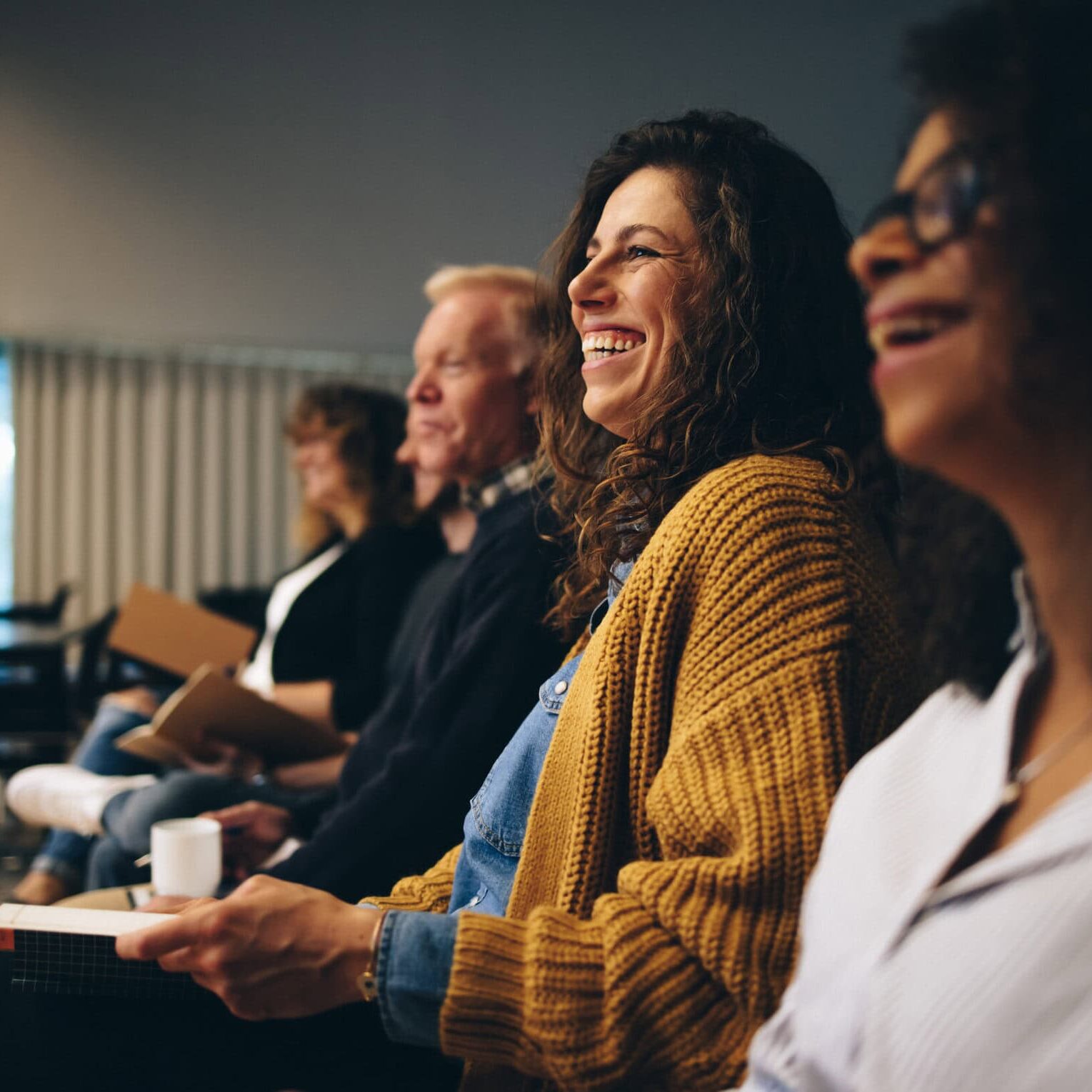 woman in focus smiling in a row at a class