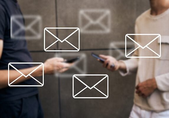 two people holding cellphones with an overlay of multiple email icons
