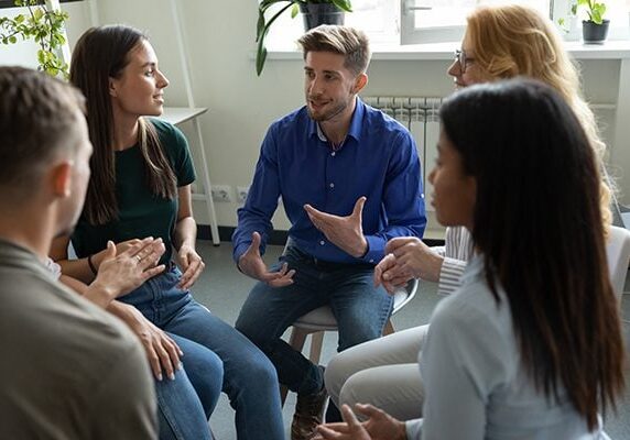 people seated in a group listening to one talking