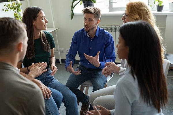 people seated in a group listening to one talking