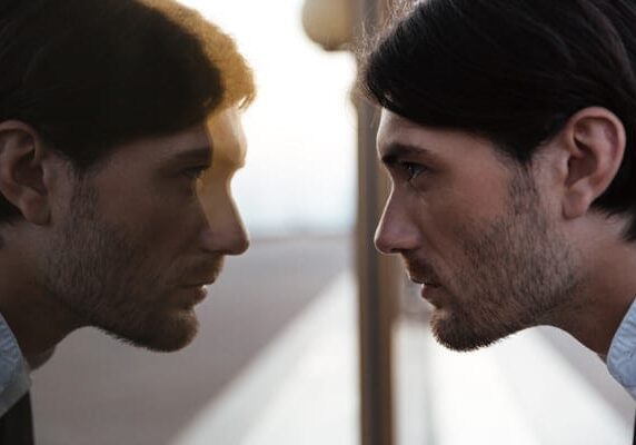 man looking at reflection in a mirror