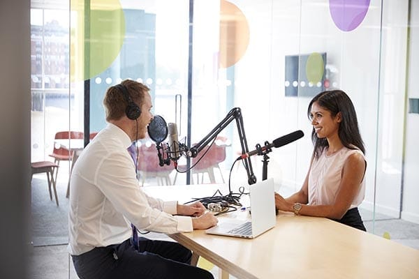 coach and interviewee recording a podcast in an office