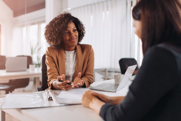 coach listening with hands open on a table while a client speaks
