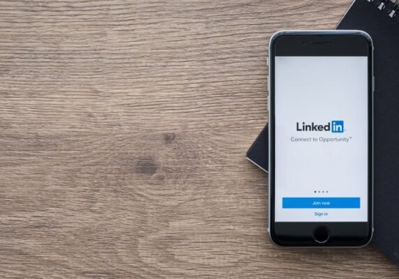 cellphone on wood table with LinkedIn app open
