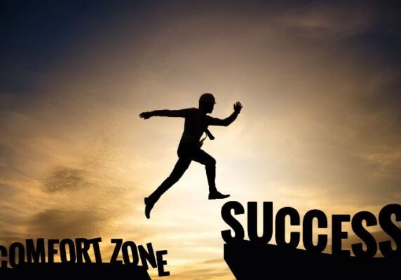 person leaping from comfort zone to success
